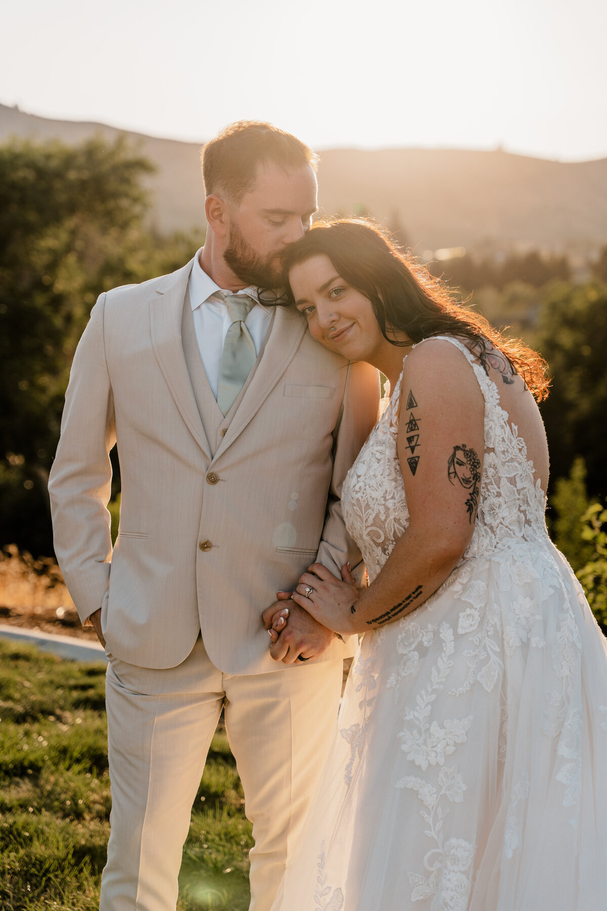 A couple kisses during golden hour at their backyard wedding.
