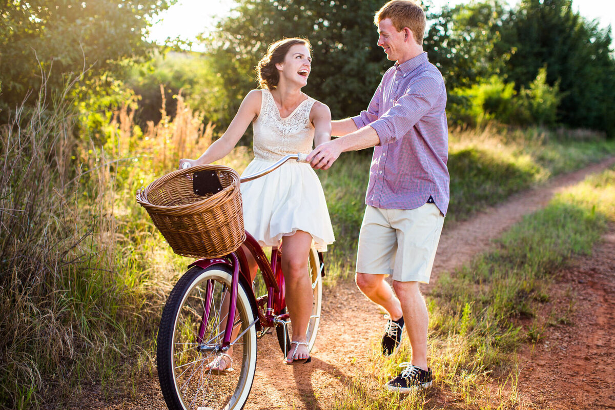 joyful candid engagement photo of couple on bike