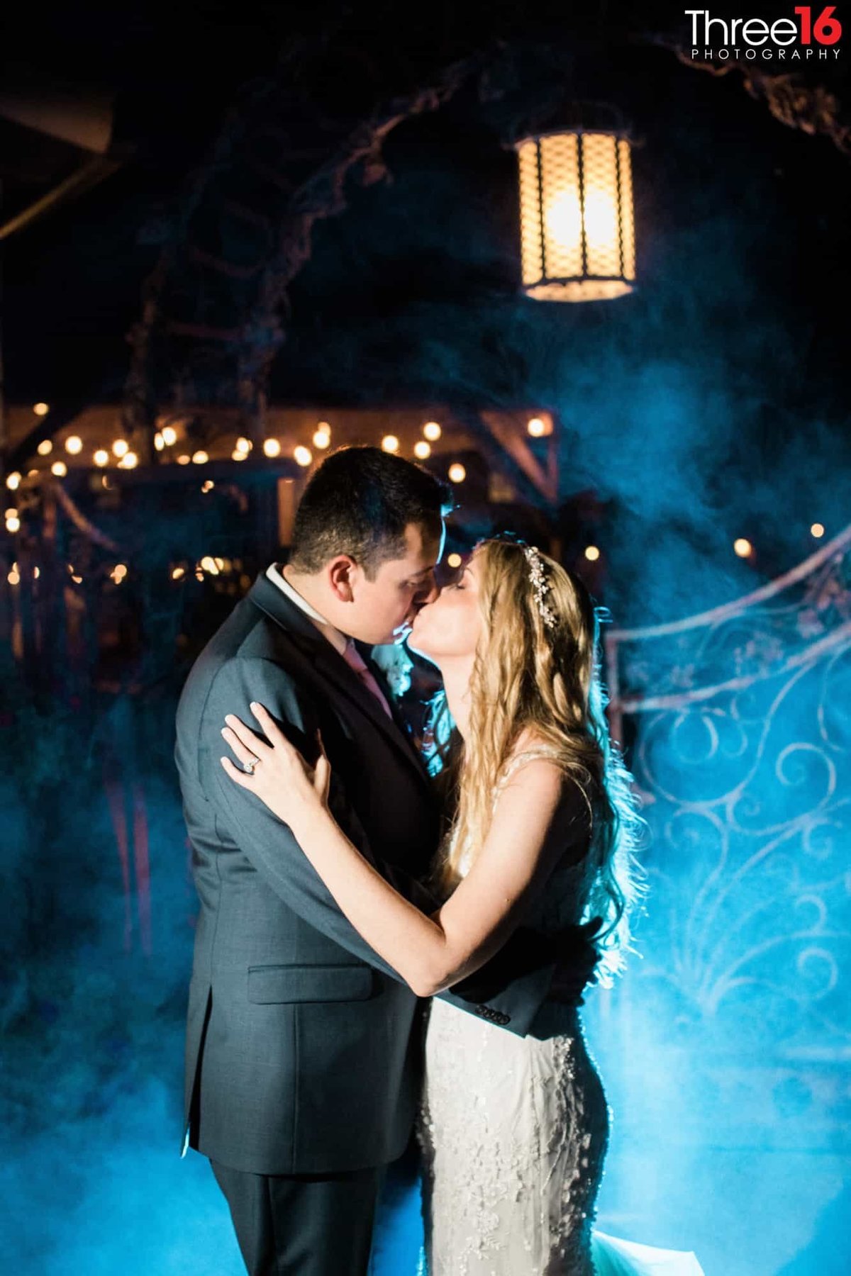 Bride and Groom share a kiss with blue fog in background