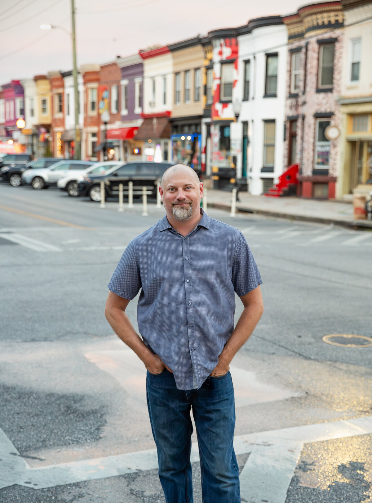 A baltimore entrepeneur poses on the street in Hampden for a headshot.