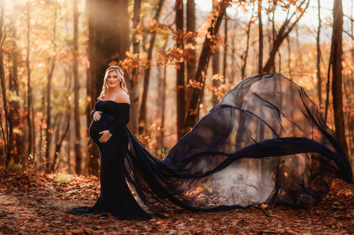 Pregnant woman poses for Maternity Portraits in autumn on the Blue Ridge Parkway in Asheville, NC.