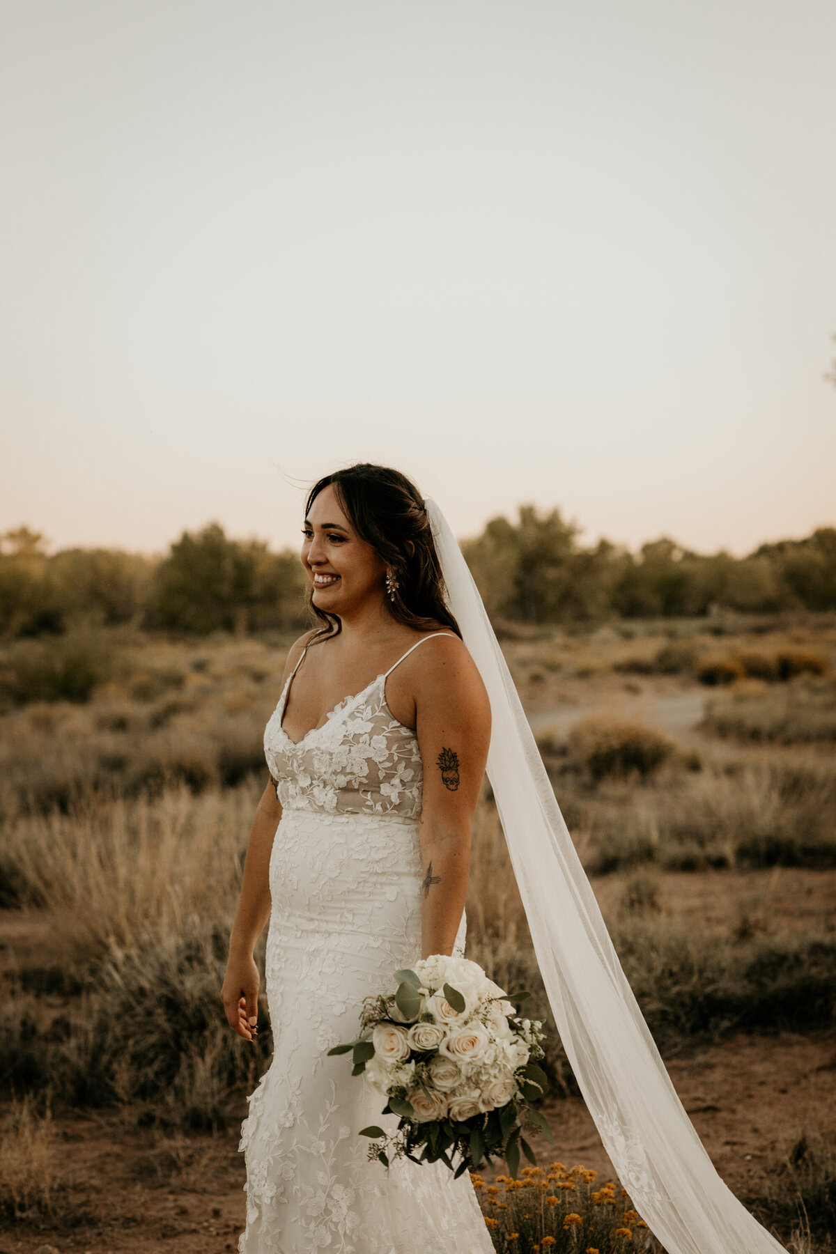 bride stanging in the desert with a long veil in Albuquerque