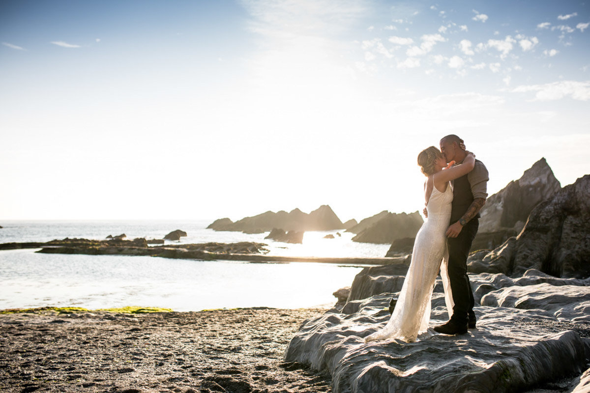 Bride and Groom kissing on the beach at Tunnels Beaches Devon