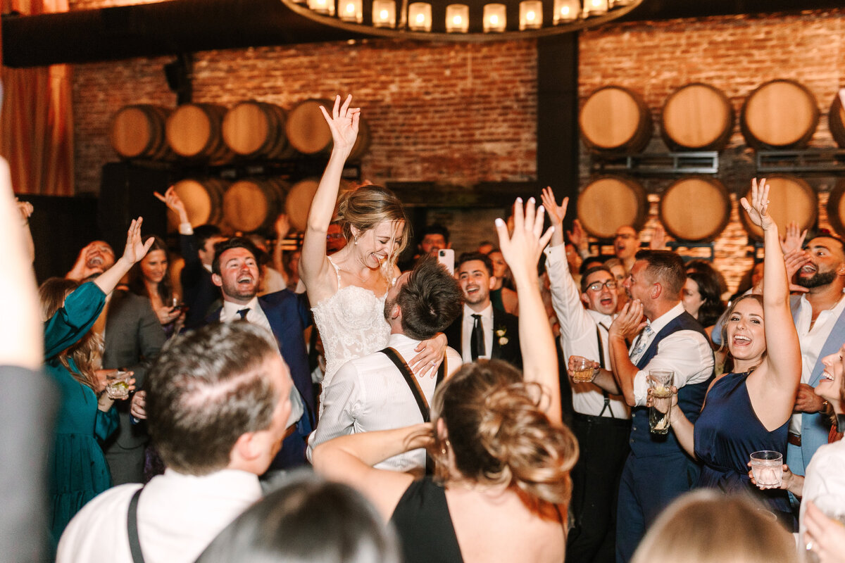 bride and groom dancing with guests happily at wedding reception in a sonoma winery.