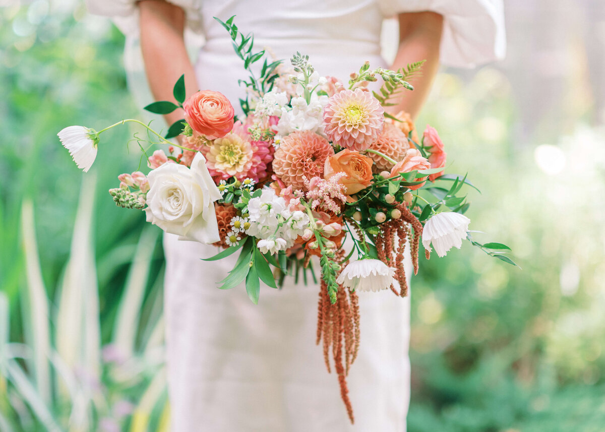 Pink, coral, and white flowers adorn the bouquet of a Virginia bride