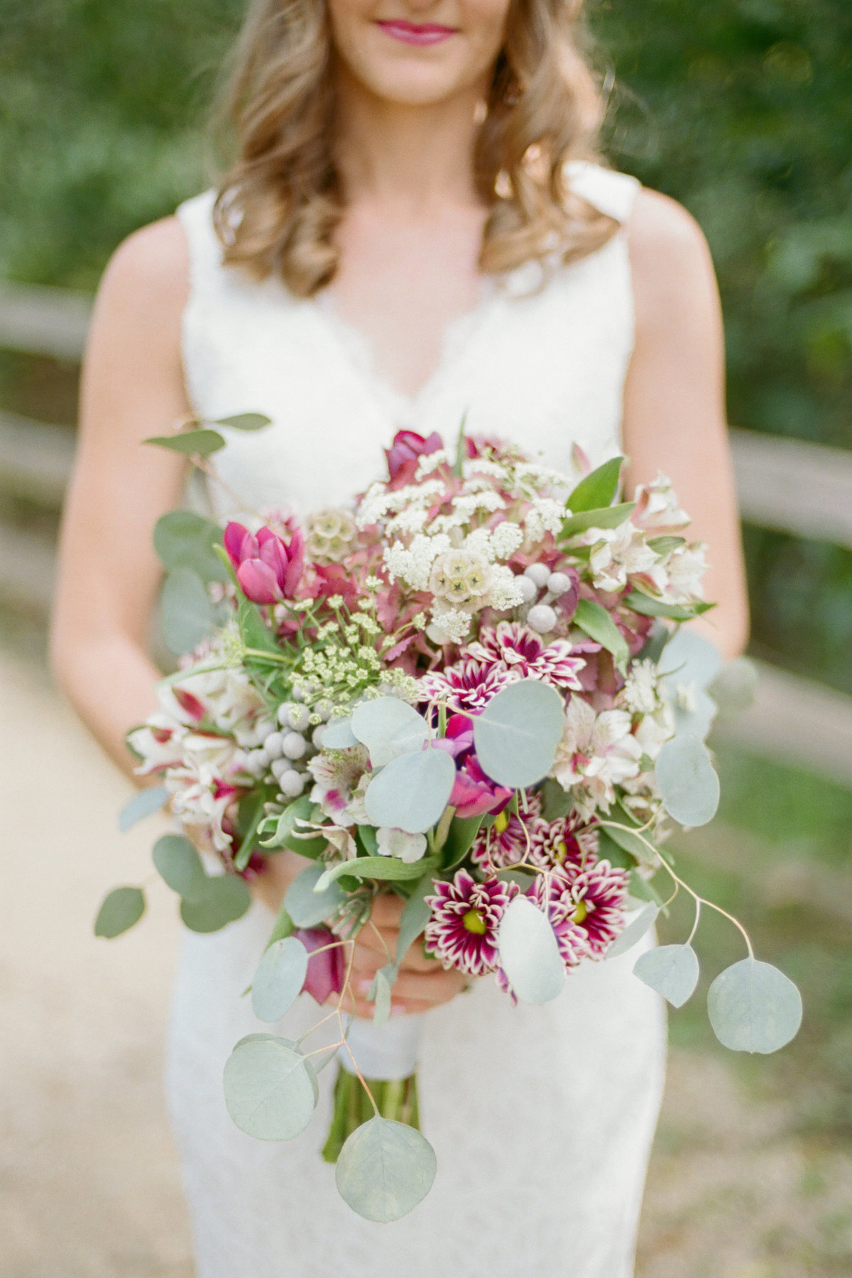 bride holding lush purple and green bouquet
