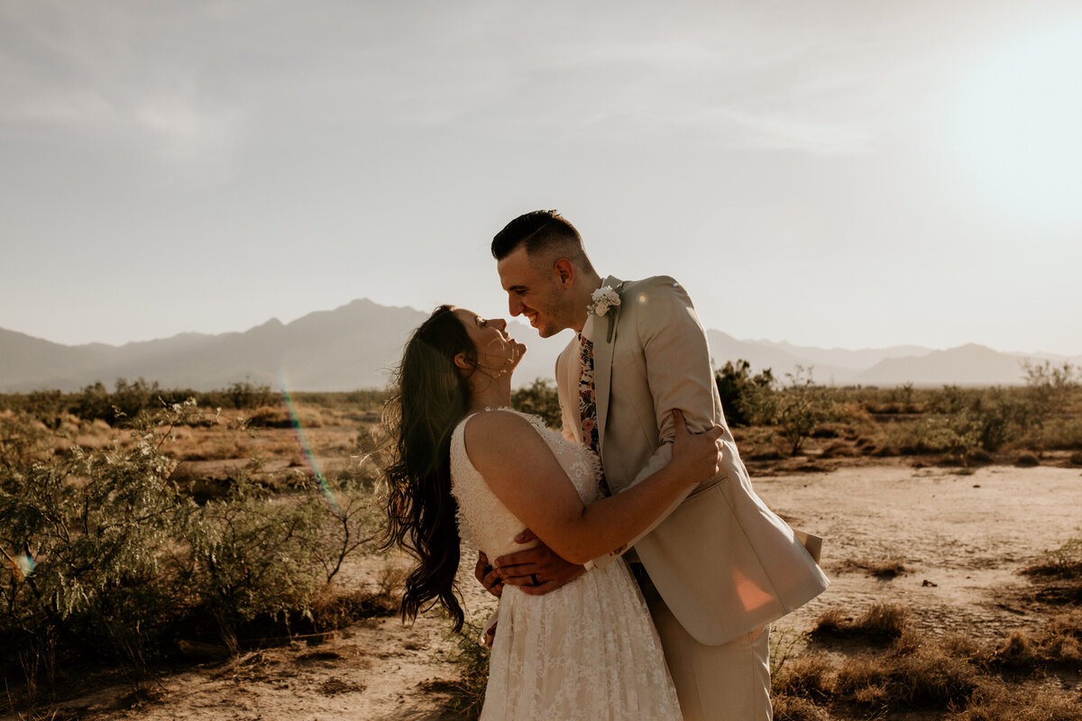 groom about to kiss new bride in the desert