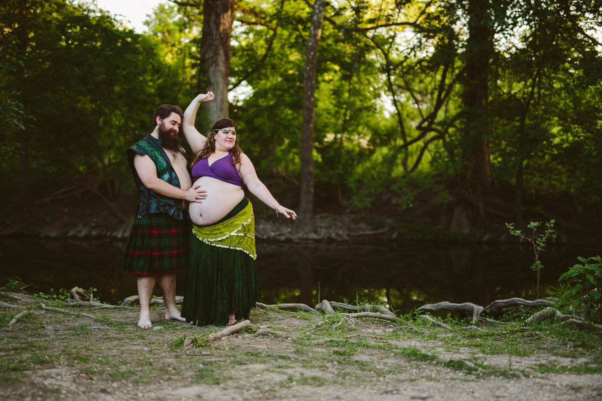 Pregnant mother and father dancing next to river in Cibolo nature Center
