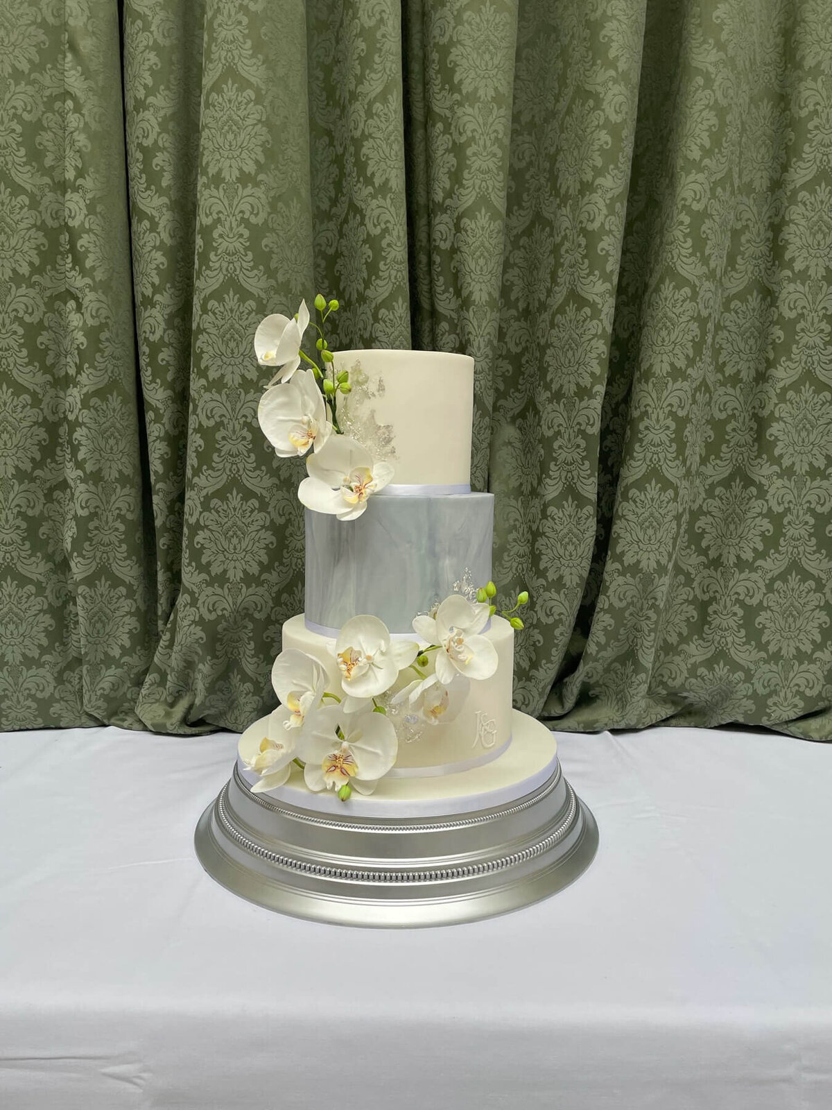 A three tier wedding  cake with orchid sugar flowers