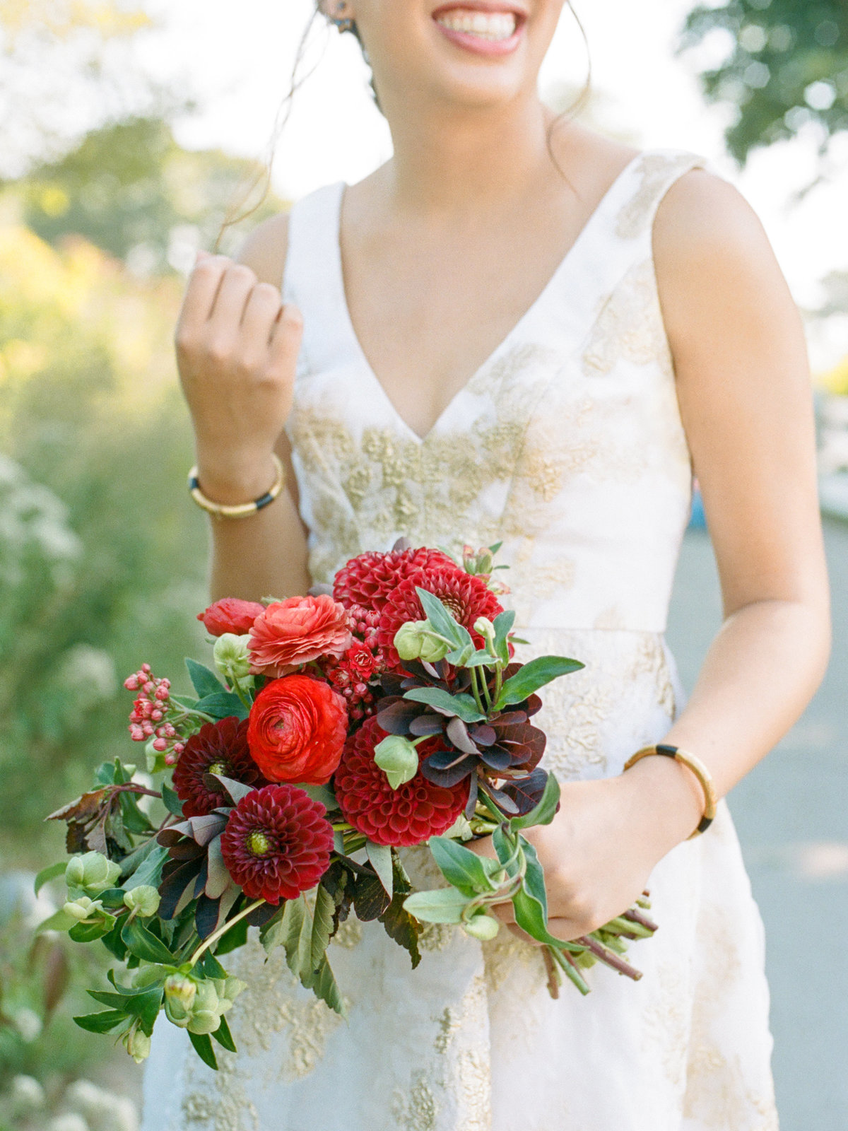 bride holding colorful red garden bouquet