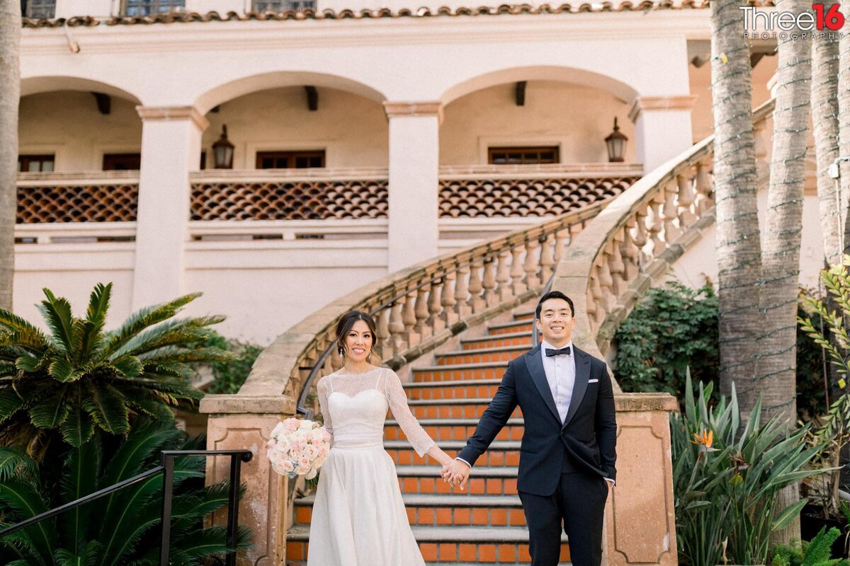 Bride and Groom pose for photos while holding hands