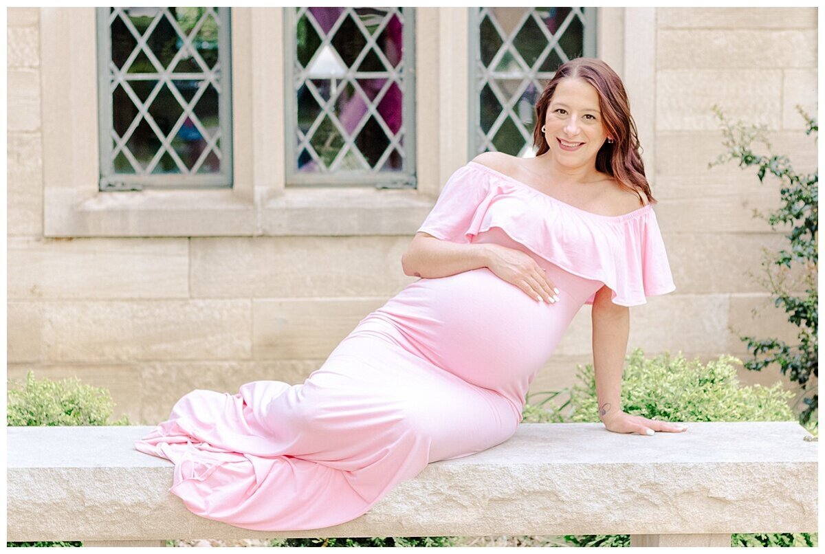 Maternity Photography in Wexford taken outdoors.  the mom is sitting and looking at her baby belly