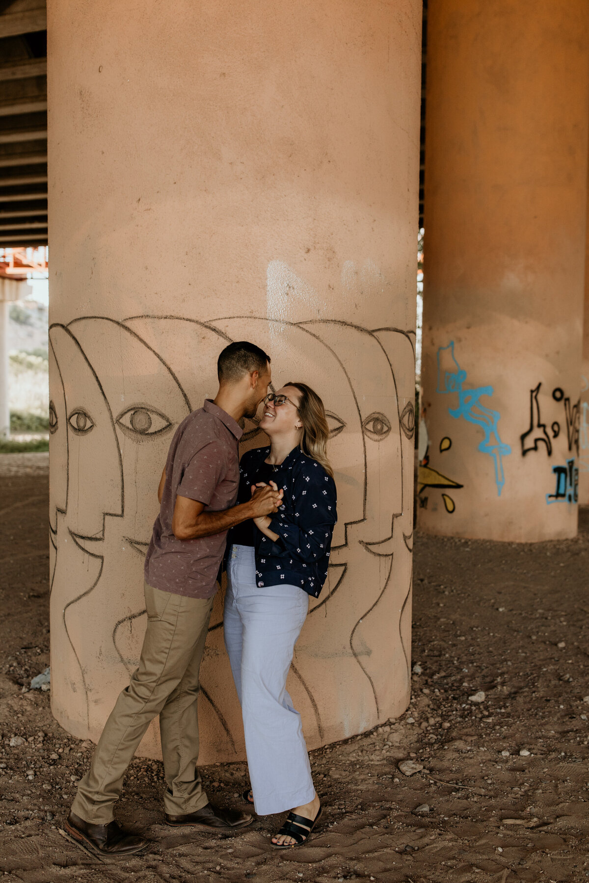 couple standing against a pillar under an overpass in Albuquerque