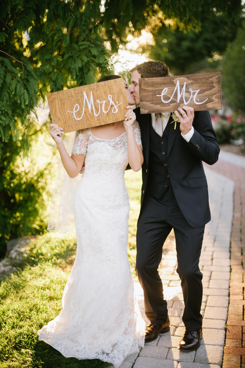 fun playful wedding mr. mrs. signs kiss candid funny bride and groom candid wedding photography