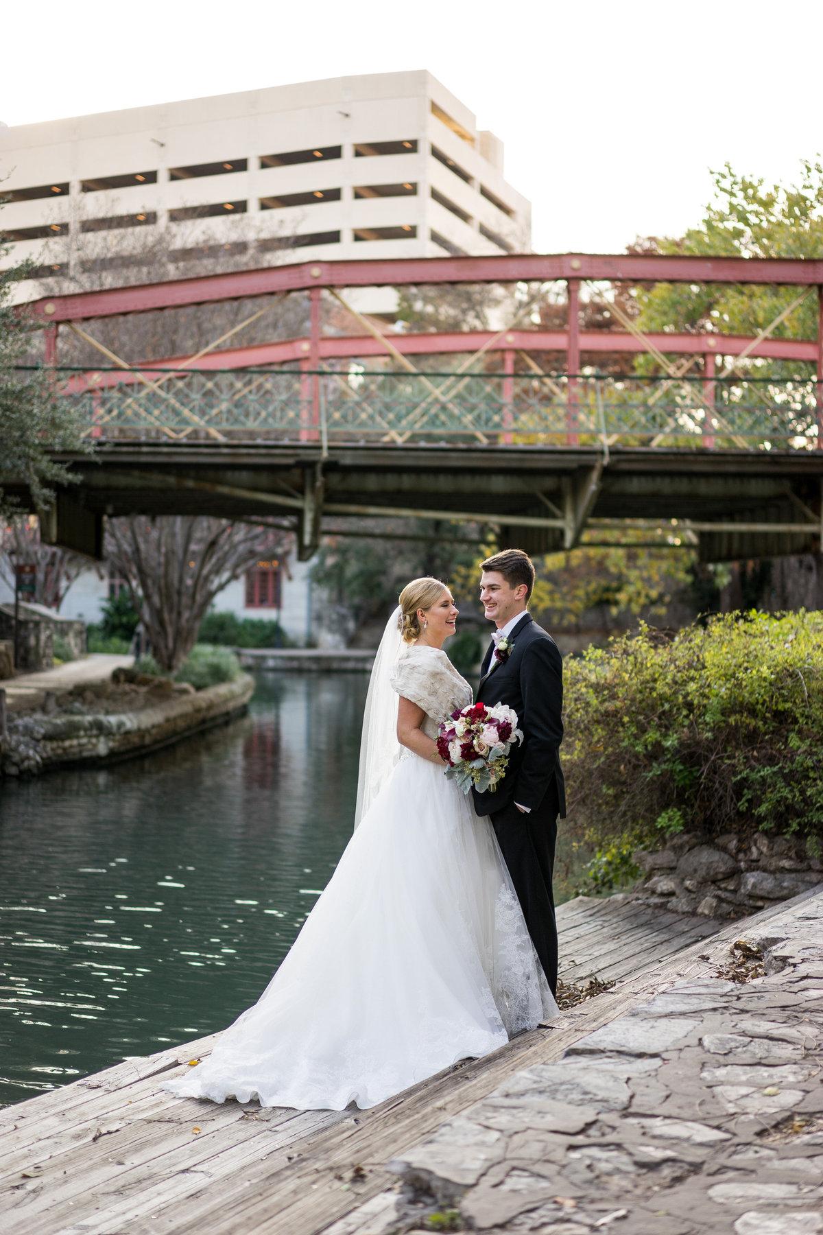 groom and bride laughing while on the San Antonio Riverwalk by The Southwest School of Art wedding venue