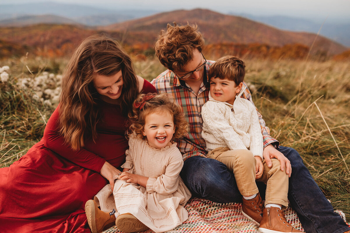 Family snuggles during Family Photoshoot at Max Patch in Asheville, NC.