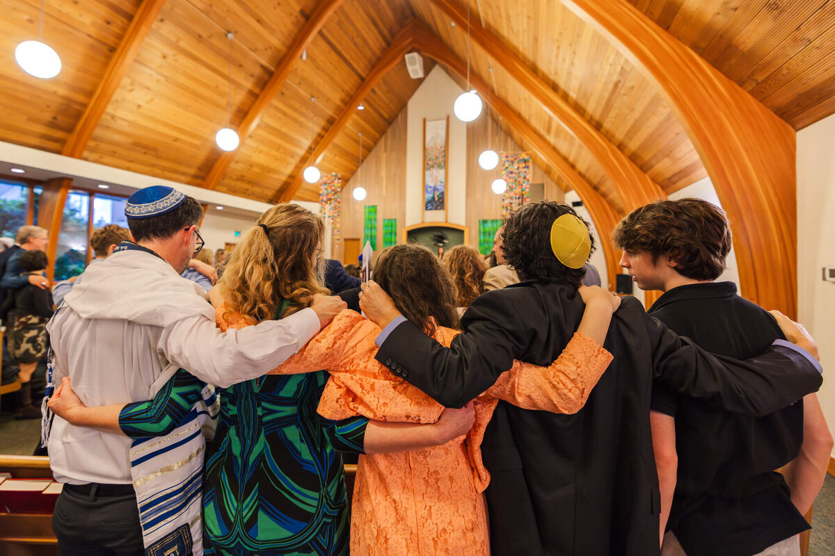 A family links arms in a bat mitzvah