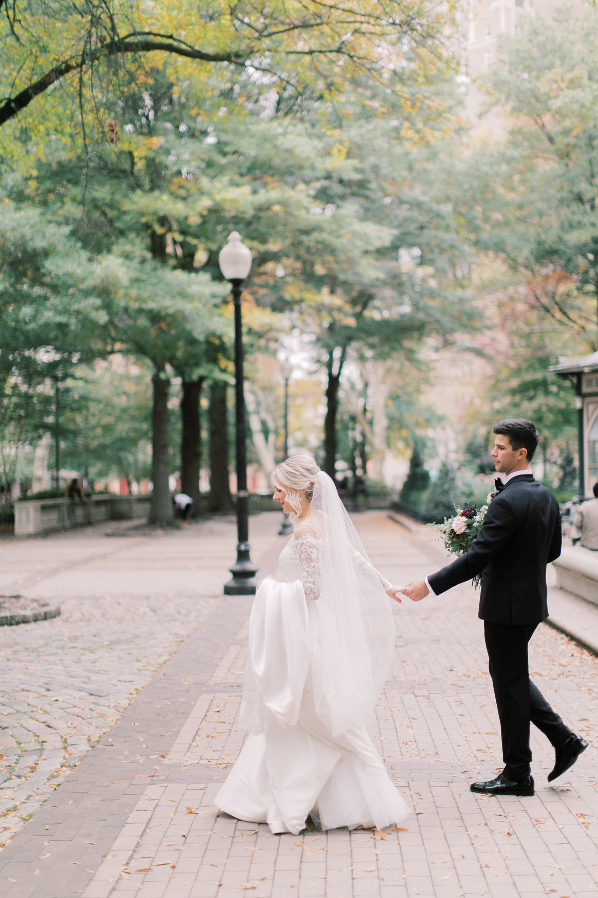 bride and groom walking down street in wedding attire