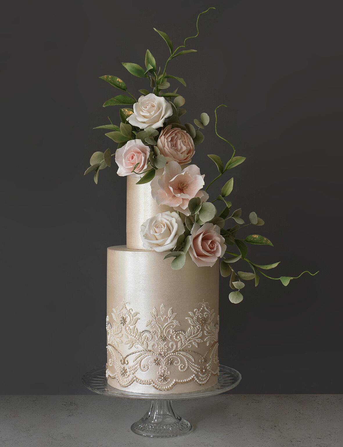 Tall two tiered wedding cake with satin finish and pale pink sugar roses and leaves