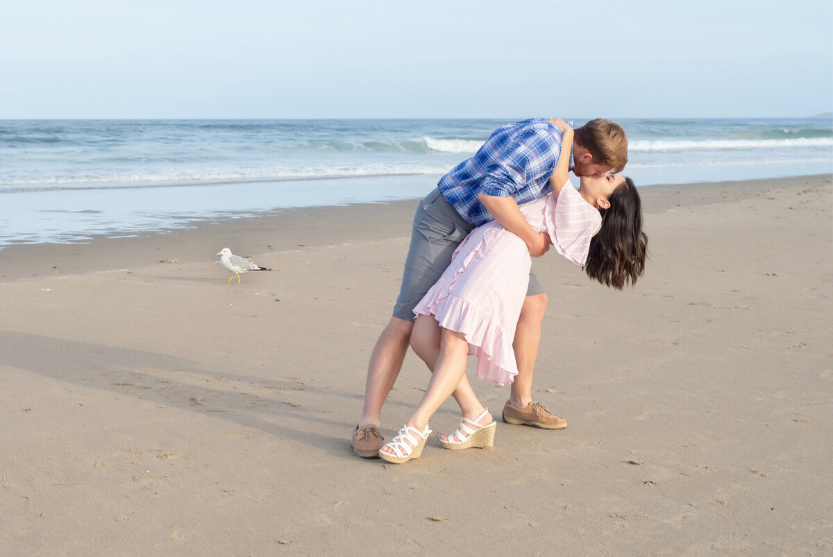 Engaged couple kissing on the beach