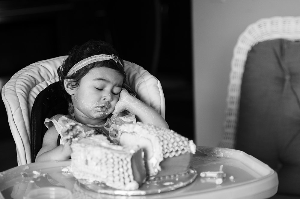 black and white photo of overwhelmed baby at cake smash