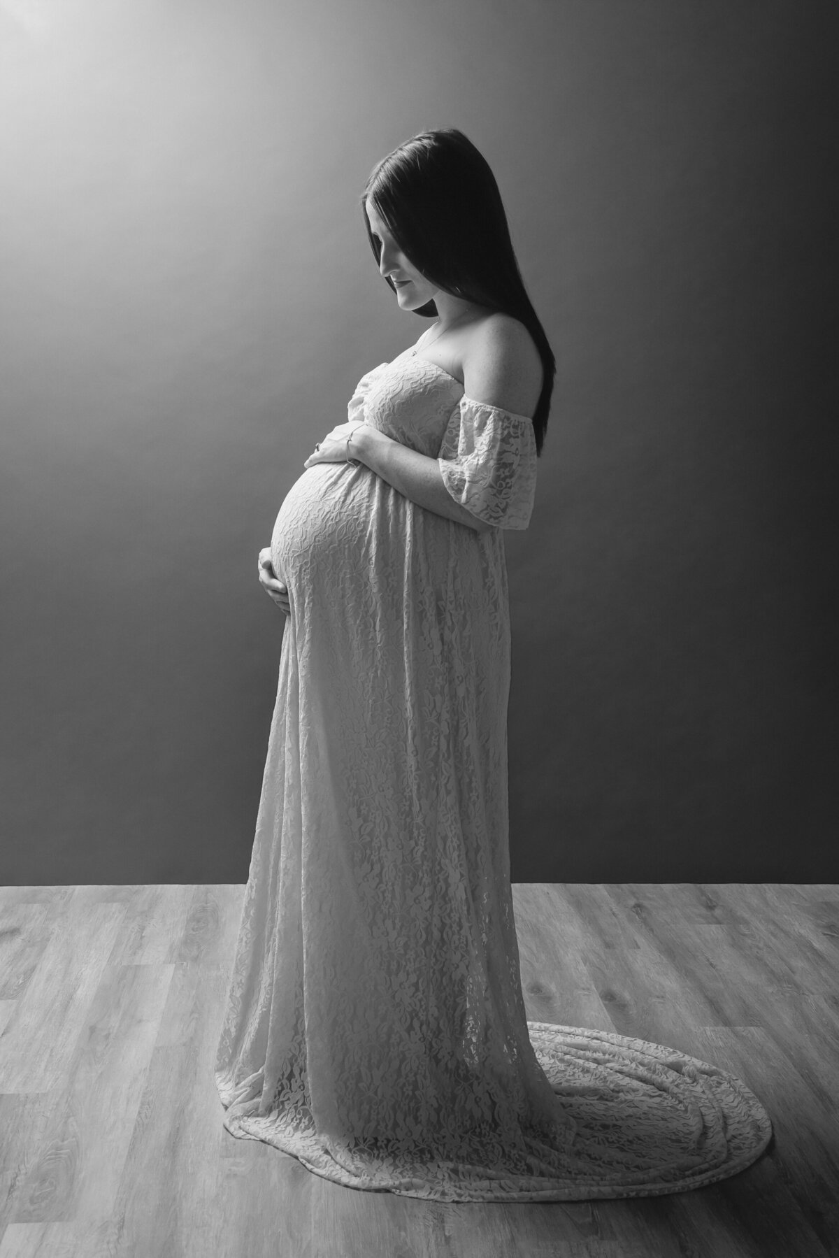 preganant woman in long  maternal dress with hands on belly