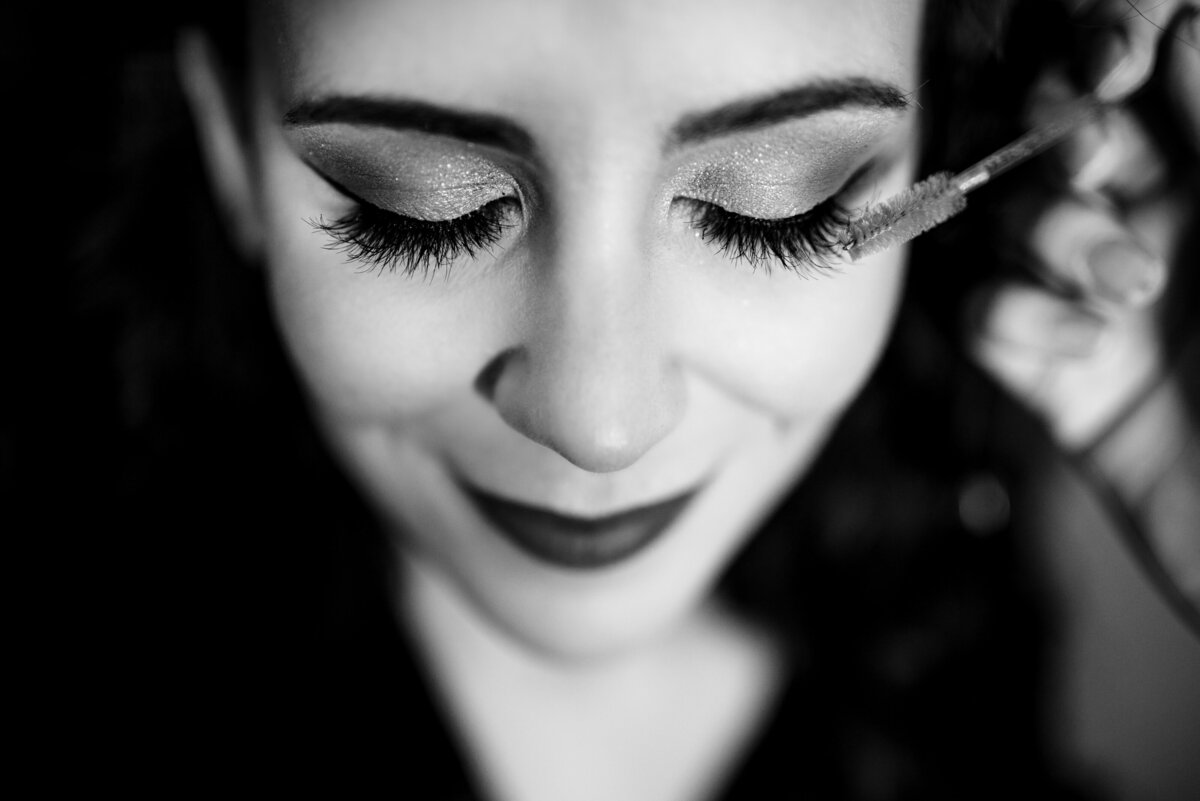 Upclose-black-and-white-image-highlighting-bride-having-her-eylashes-as-her-mascara-is-applied