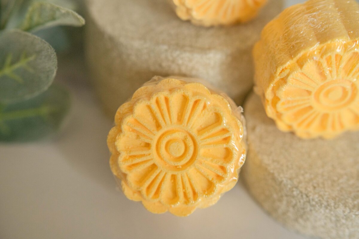 Yellow, floral patterned mooncakes displayed next to each other with soft focus background.