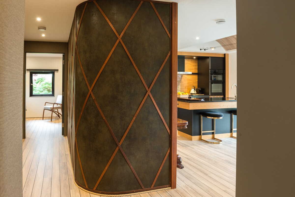 Hallway with curved, leather covered dividing wall and wood lattice design