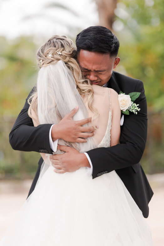 groom embracing bride and crying
