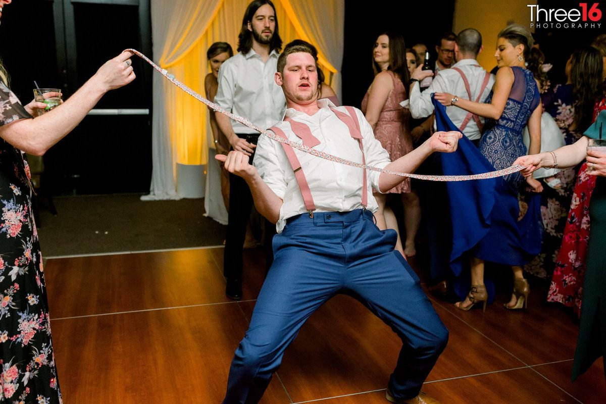 Wedding guest does the limbo on the dance floor during wedding reception