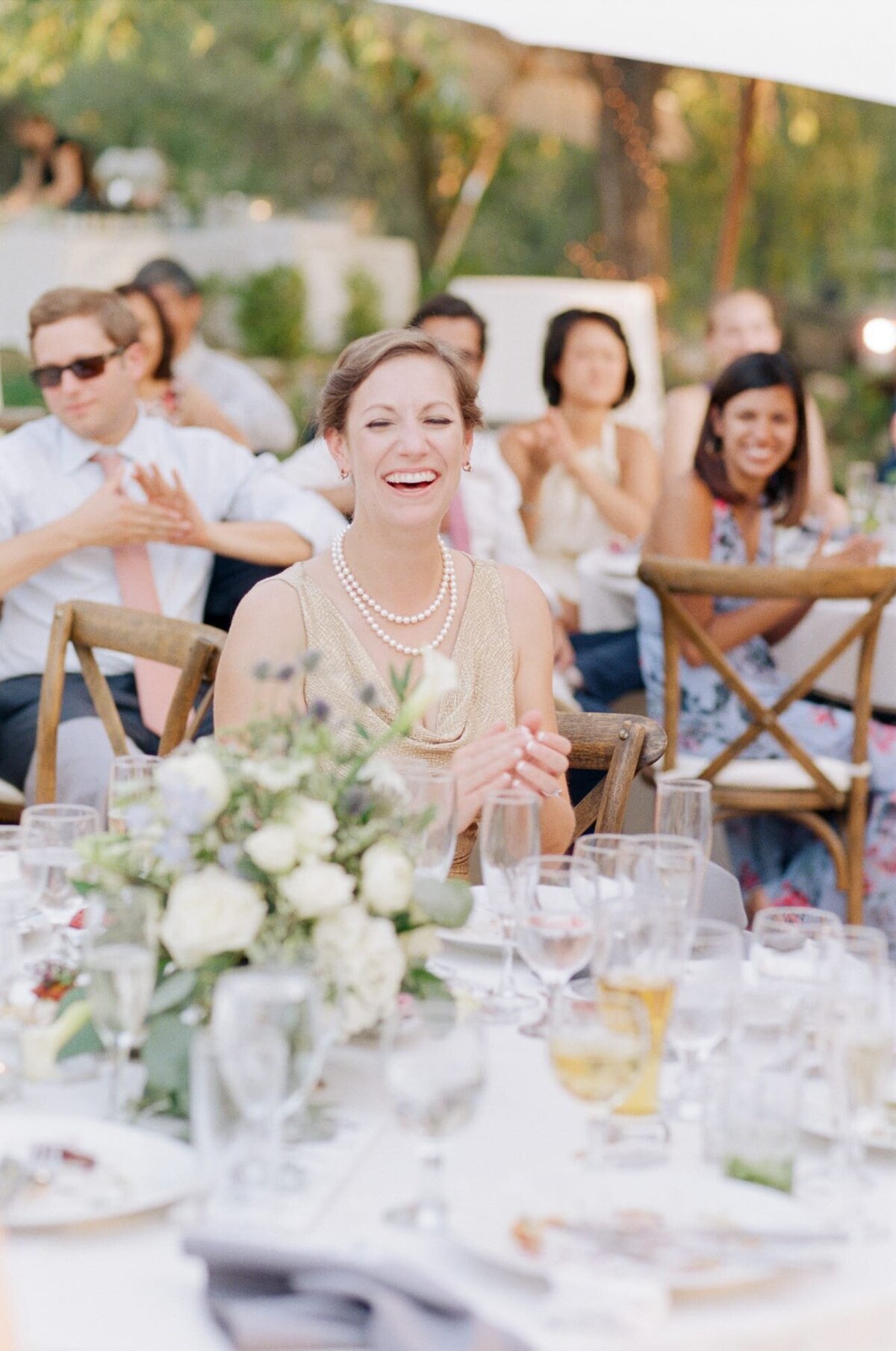 Bride finally sits at her beautifully decorated reception table and entertains her guests.