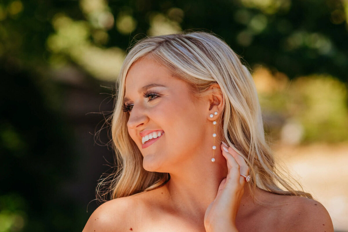 Photo of a bride showing off her wedding day earrings