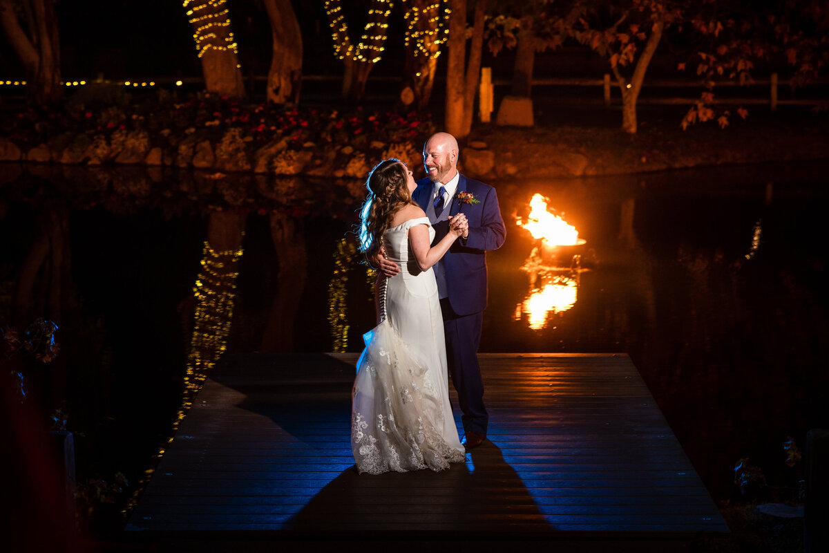 Bride and groom dancing  with fire and lights in the background