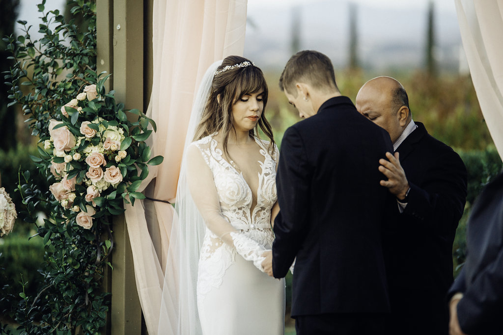 Wedding Photograph Of Bride And Groom Bowing Their Heads In Front Of Pastor Los Angeles