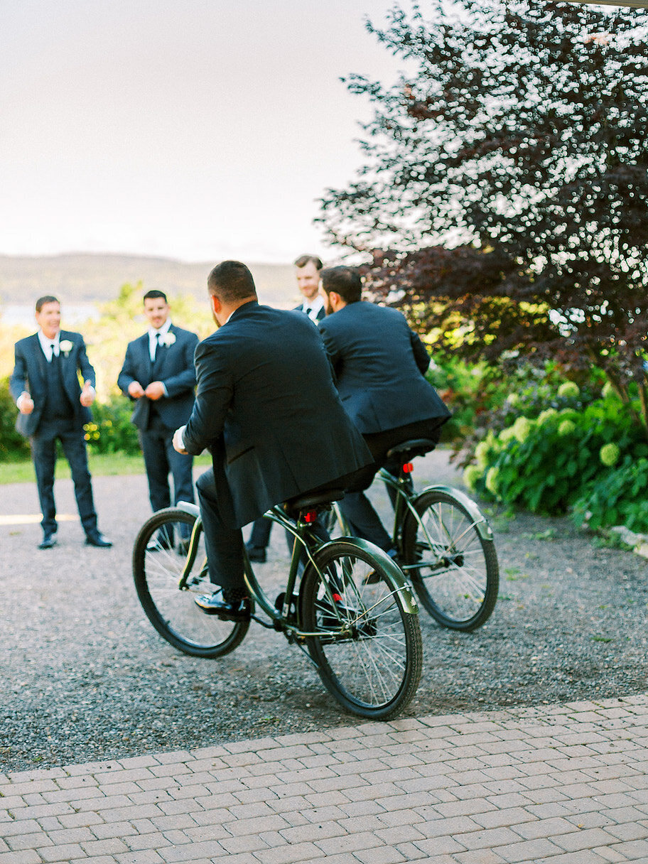 Groomsmen on bikes during a getting ready moment at a destination wedding