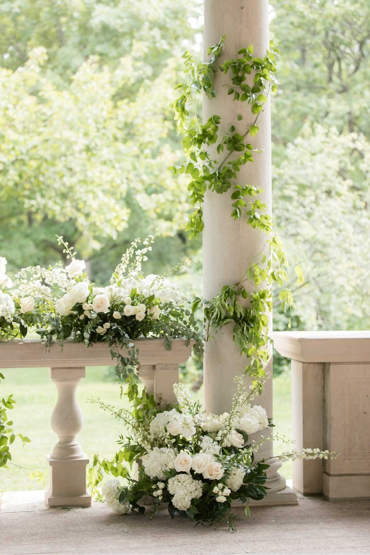 Garden inspired ceremony floral with greenery on the columns  at Columbus Park Refectory for a Luxury Chicago Outdoor Historic Wedding Venue.