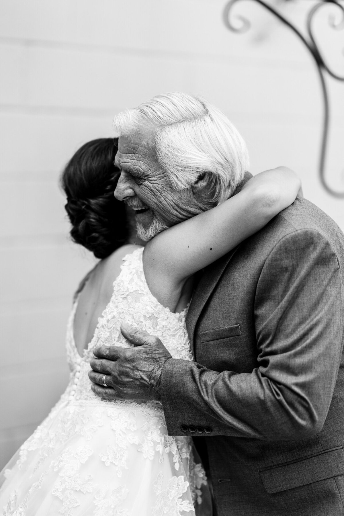 Bride hugs grandpa at wedding reception.