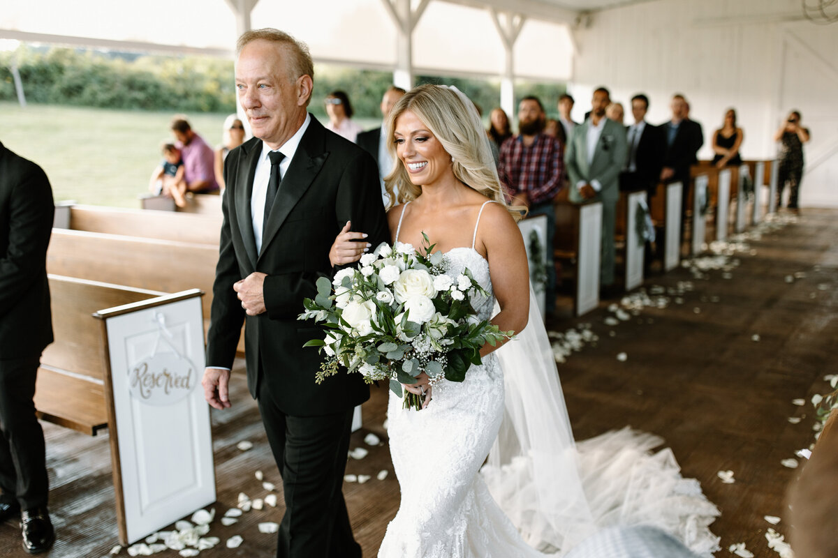 Bride walking with her father down the aisle at White Dove Barn