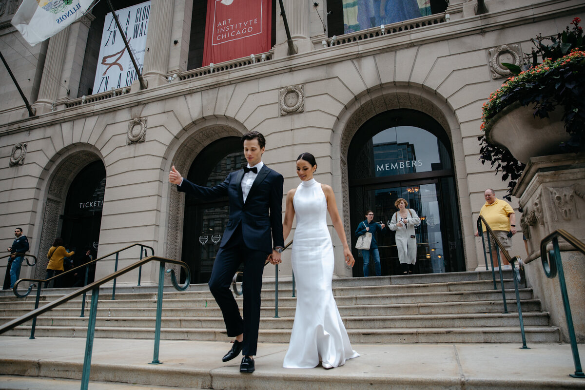Couple walking outside on the steps of the Art Institute of Chicago after bridal portraits