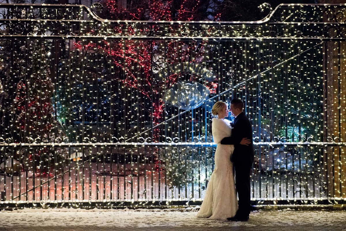 Bride and groom kissing at the gate at Fox Hollow