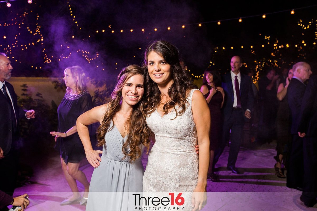 Bride posing with a Bridesmaid on the dance floor