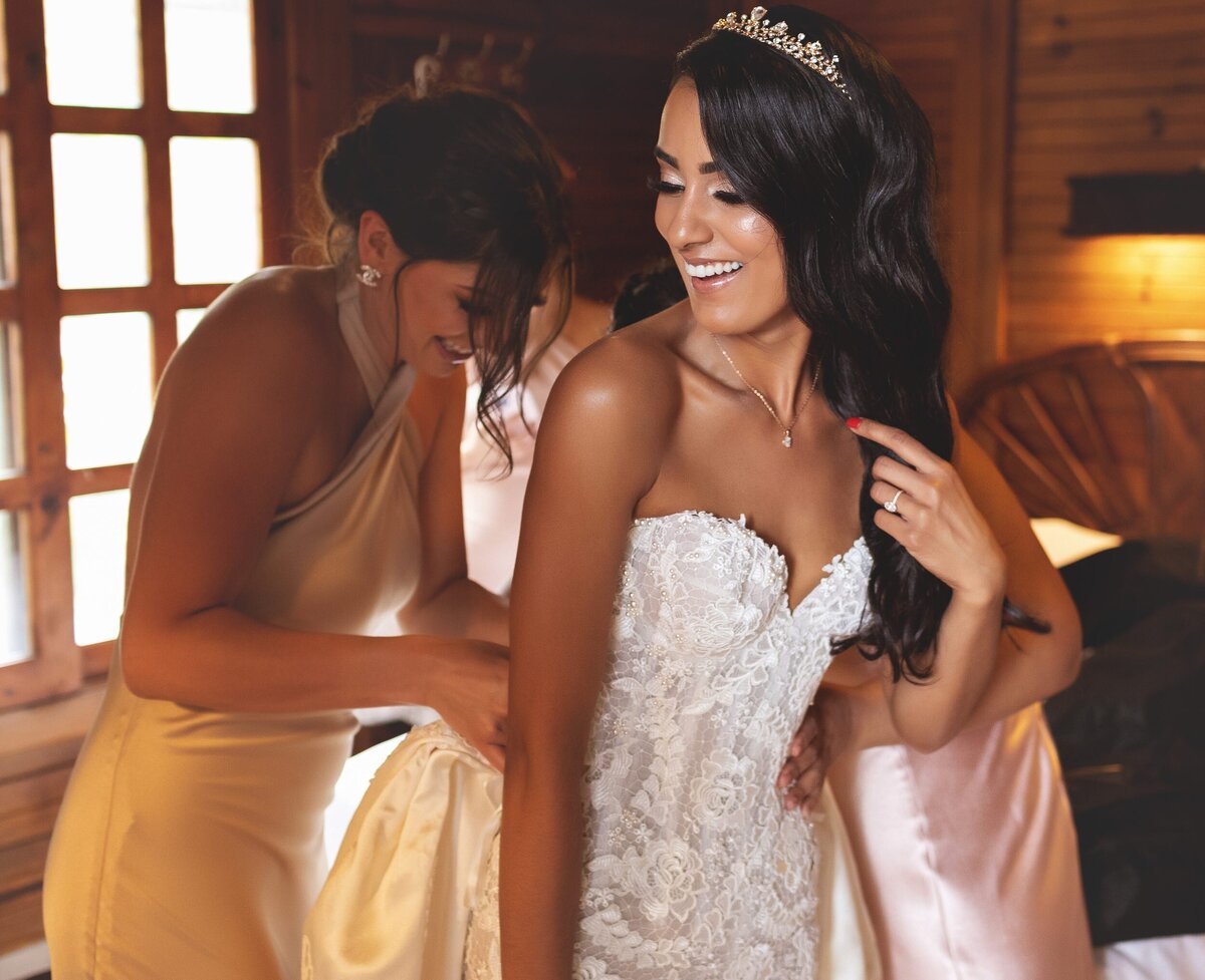 Bridesmaid helping bride into dress at Riviera Maya Wedding