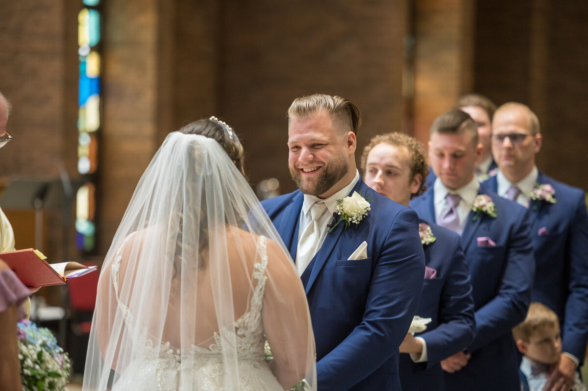 Groom looking at bride during wedding ceremony.