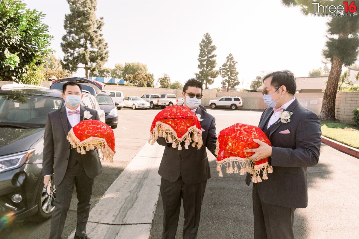 Groomsmen arrive at the ceremony bringing special items for Chinese Wedding