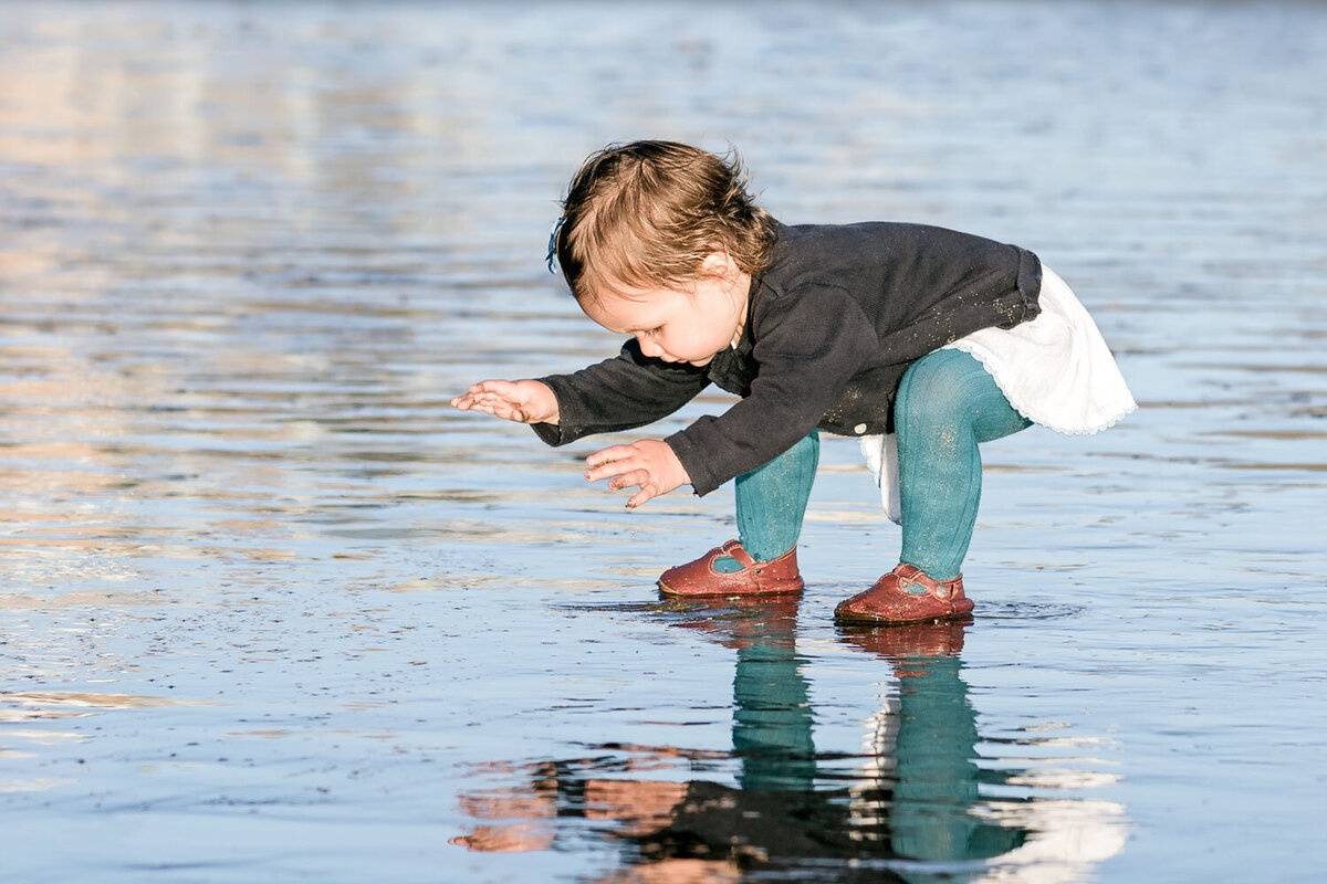 toddler girl playing in water