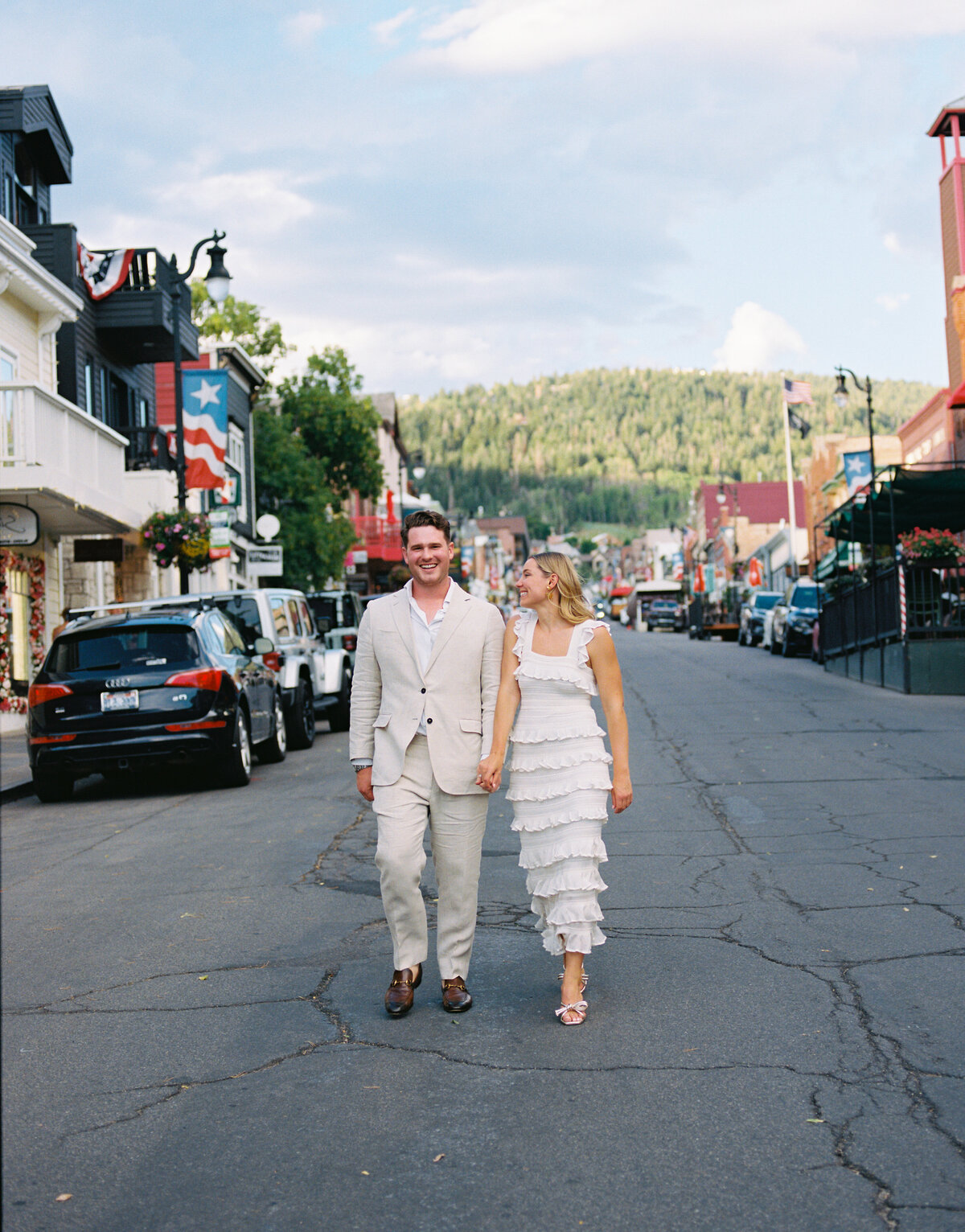 couple hold hands walking the streets of park city utah