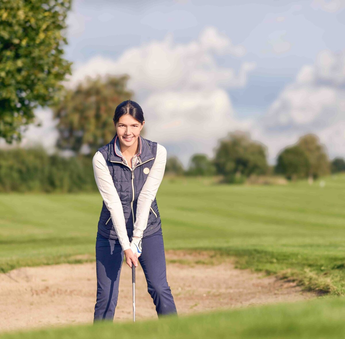 HS Senior girl golfing on a sunny day in April, positing for her  high school senior photographs.
