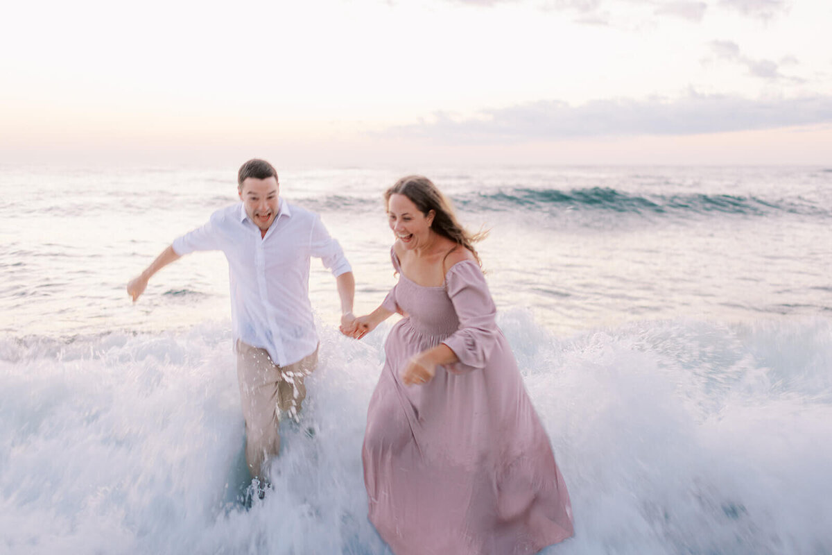 couple-hit-with-waves-at-beach