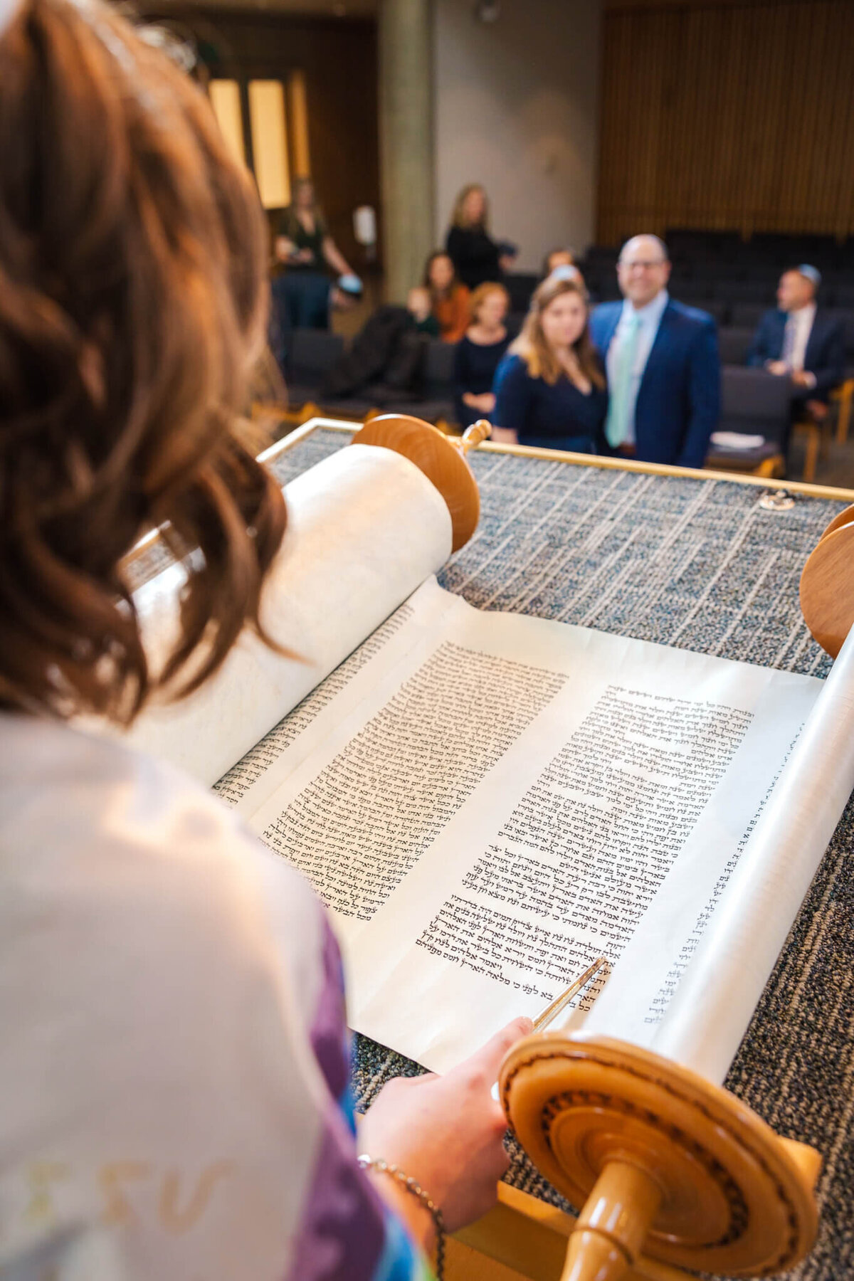 A look over the shoulder of a teen girl practicing her Haftarah for mom and dad at the bimah during a Bellevue Bar and Bat Mitzvah Photography session